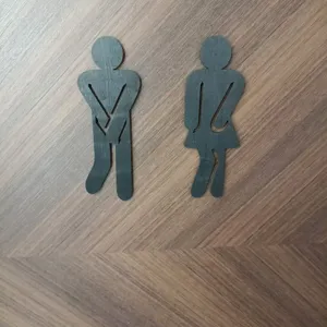 Wooden toilet door sign detail view, funny silhouette design for restroom wall decor.