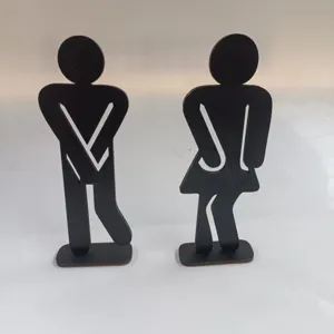 Detailed close-up of wooden silhouette bathroom sign figures, creative toilet door decor item.