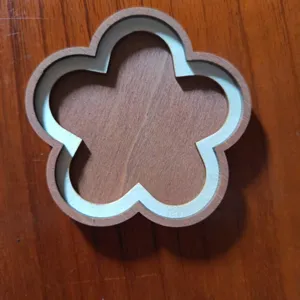 Detalle de accesorio de marco de bordado DIY con forma de flor de madera, material natural.