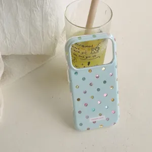 Close-up detail of light blue phone case with shiny holographic polka dots and aesthetic background.