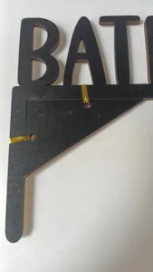 Detail de decor de lettres en bois, finition noire decoupee pour maison et fete de vacances.