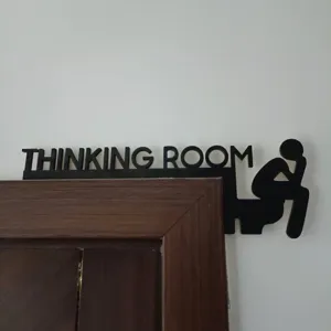 Vue détaillée d'une décoration de porte en bois noir avec lettres et silhouette drôle.