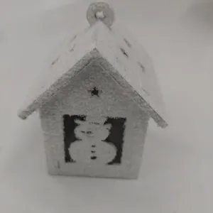 Wooden Christmas snow house ornament with fake snow and snowman cutout for holiday decor.