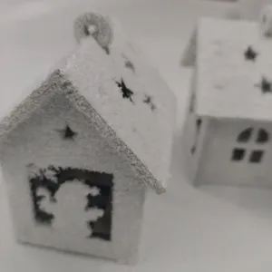 Wooden Christmas snow house ornament detail, miniature hanging wooden cabin decor.