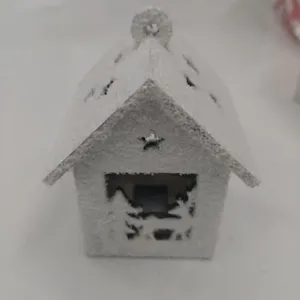 Flocked wooden Christmas house ornament with snow, star cutout, and hanging loop for holiday decor.