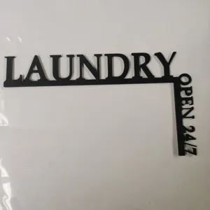Vue détaillée de l'enseigne d'angle noire en bois laundry open 24/7, décoration murale.