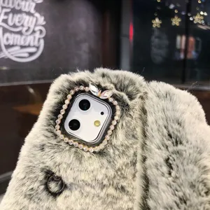Custodia per cellulare in pelo grigio soffice con strass e fiocco in cristallo per inverno.