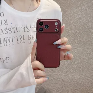 Close-up detail shot of the dark red leather texture phone case, showing premium grip and design.