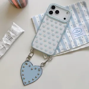 Vue rapprochée de la coque transparente en strass avec motif de cœur et lanière cloutée.