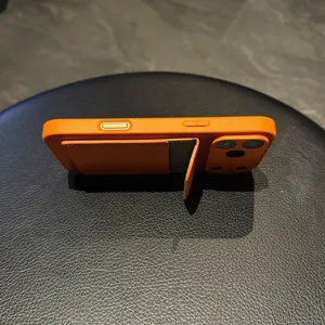 Orange leather phone case with card holder and kickstand, compatible with iPhone max models.