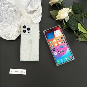 Square iridescent shell texture phone case detail, elegant white floral background showcase.
