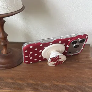 Red polka dot phone case detail view, featuring cute white stars and a convenient collapsible stand.