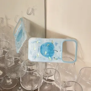 Detail view of the gradient blue apple and goldfish phone case, featuring a cute design.