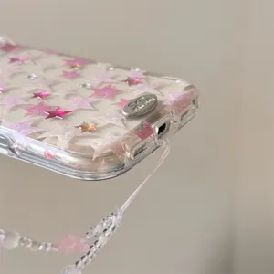 Primo piano di una custodia per telefono trasparente con stelle rosa e cordino di perle.