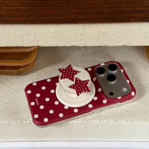 Detailed view of red polka dot phone case with cute star bracket for iPhone models.