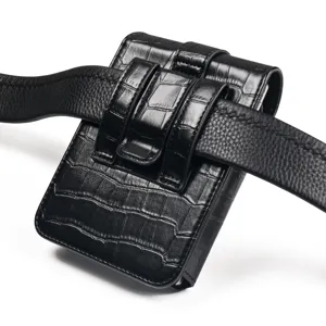 Closeup detail of black crocodile leather phone belt pouch displayed on black leather strap.