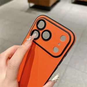 Detail van oranje geweven textuur telefoonhoesje met nauwkeurige camera-uitsparingen en stof.