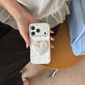 Close-up detail of cute Korean style star pattern phone case with heart stand for Apple.