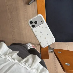 Detail shot of Korean style colorful star phone case, cute white protective back cover accessory.