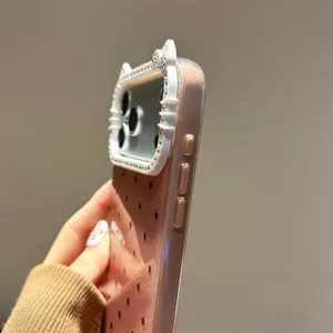 Primer plano detallado de la funda de teléfono con estrás brillante y orejas de gato con lunares.