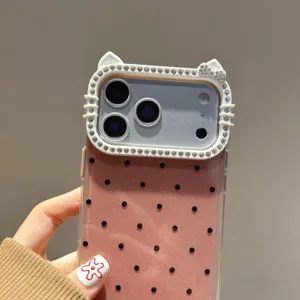 Primer plano detallado de funda de teléfono con lunares brillantes y orejas de gato con diamantes.