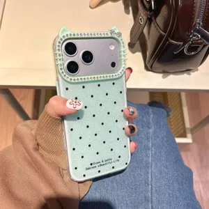 Vista detallada de la funda de teléfono de lunares verdes con marco de cámara strass de gato.