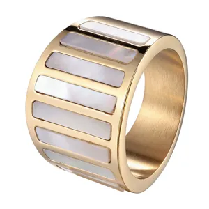 Bague en acier titane plaqué or avec incrustations de bandes de nacre blanche.