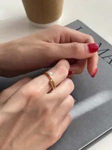 Gros plan du détail de la bague ouverte perle bambou dorée minimaliste, bijou élégant.