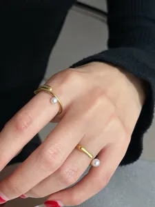 Gros plan de la bague ouverte élégante en perle dorée sur la main, vitrine de bijoux.