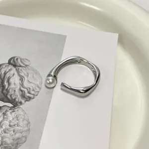 Bague ouverte argentée minimaliste avec perle, design chic et élégant pour un usage quotidien.
