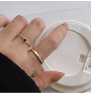 Conjunto de anillos minimalista en acero de titanio con circonita verde y nácar fino.