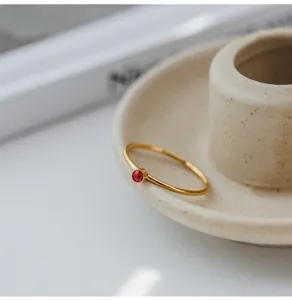 Exquisito anillo minimalista de acero de titanio con piedra de circonita roja para mujeres.