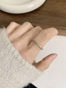 Detailed shot of a delicate rainbow cubic zirconia ring featuring sparkling multi-colored stones.