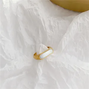 Gedetailleerde close-up van de minimalistische vergulde roestvrijstalen ring met schelp.