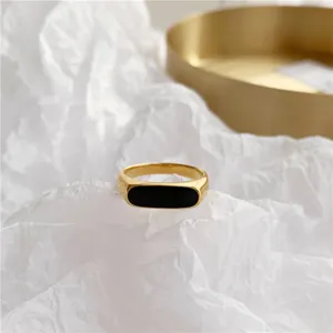 Minimalistische 18k vergulde titanium staal ovale ring, chique retro zwart inleg sieraden detail.