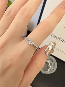 Gros plan sur le détail de la bague en zircone marquise, design en métal argenté épuré.