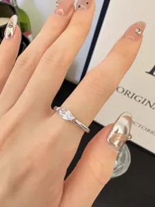 Gros plan d'un anneau minimaliste en zircone cubique taille marquise au doigt, bijoux.