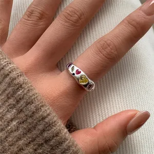 Gros plan détaillé de la bague massive en acier titane présentant des zircons multicolores.