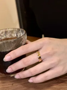 Gros plan de détail d'un anneau alvéolé hexagonal minimaliste avec finition or rose.