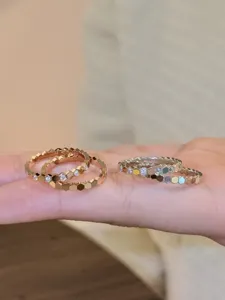 Gros plan bague alvéolée hexagonale, design minimaliste de bijoux géométriques en métal.