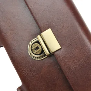 Detail view of the vintage brown leather waist pouch metal lock clasp and texture.