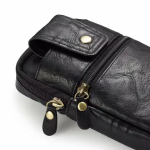 Vue détaillée du sac banane multifonction en cuir noir avec zips et boutons pression.