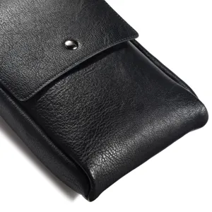 Close-up detail of black leather vertical phone pouch holster with metal snap button closure.