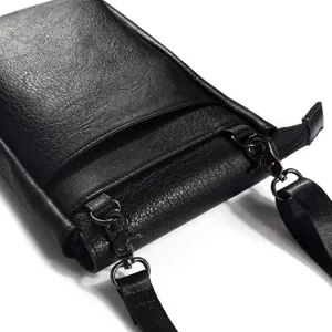 Close-up detail of black vertical leather phone bag featuring durable metal hardware hooks.