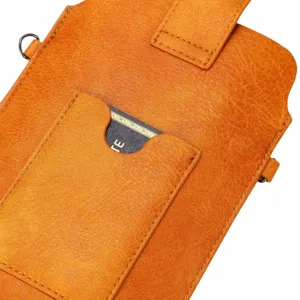 Detail van kaartsleuf van oranje leren telefoonhoes met fijne textuur en metalen ringen.