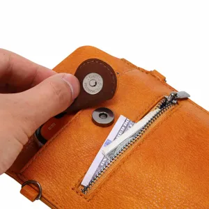 Close-up detail van de stijlvolle oranje lederen crossbodytas met drukknoop en handig ritsvak.