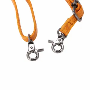 Gedetailleerd overzicht van de verstelbare oranje lederen tassenriem met metalen haken.