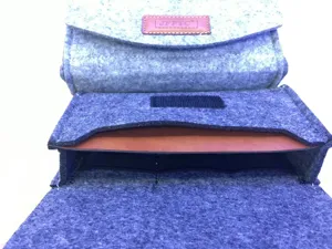 Close-up detail of grey and blue felt phone pouch organizer with leather brand tag, multi-layer slots.