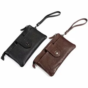 Détail en gros plan d'un portefeuille pochette en cuir avec lanière et poche à pression.