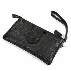 Vue de detail du sac clutch en cuir noir avec une dragonne pratique et une fermeture eclair.